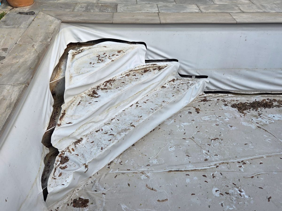 Escalier d’angle d’une piscine Desjoyaux, avec son ancien liner déchiré