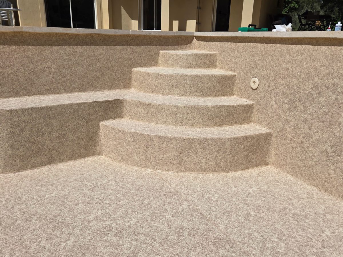 Escalier maçonné d’angle arrondi et banquette recouverts en PVC armé Aquasense Granit Sand (CGT Alkor)