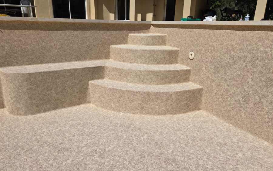 Escalier maçonné d’angle arrondi et banquette recouverts en PVC armé Aquasense Granit Sand (CGT Alkor)