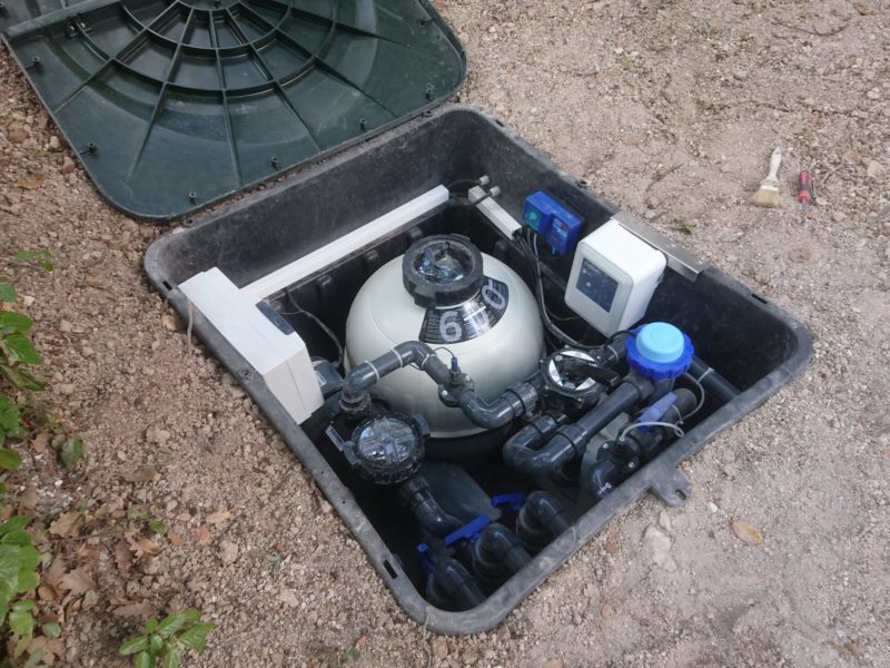 Coffre de filtration enterré, ouvert : filtre, pompe et vannes