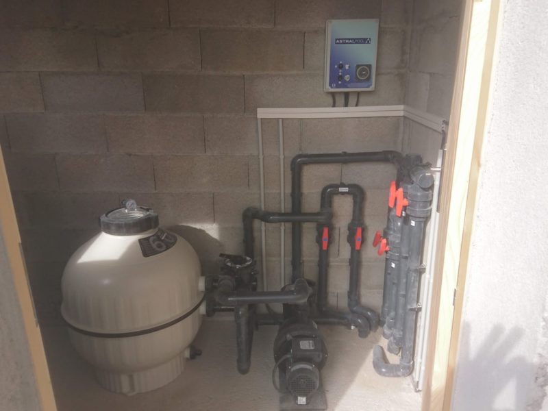 Petit local technique de piscine : filtre, pompe et coffret de régulation